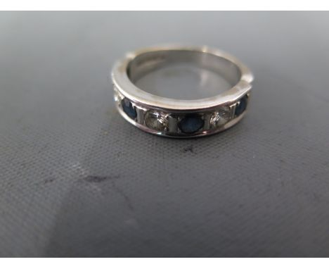 An 18ct white gold solitaire and diamond ring - seven stones, alternate sapphire and diamonds - ring size P/Q - approx weight