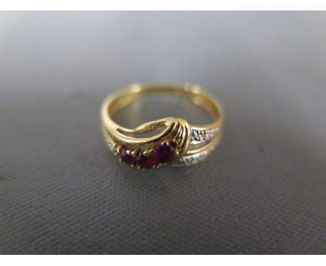 An 18ct yellow gold ruby and diamond crossover ring size K/L - approx weight 2 grams - in good condition, some usage wear