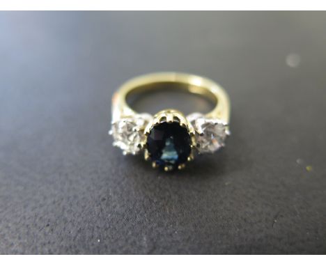 An impressive 18ct yellow gold sapphire and diamond ring, the central sapphire approx. 8 x 6mm flanked either side by brillia