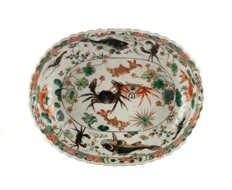 A Chinese porcelain famille verte oval bowl, Qing, Kangxi period (1662 - 1722), the deep fluted sides with gilt rim, the inte