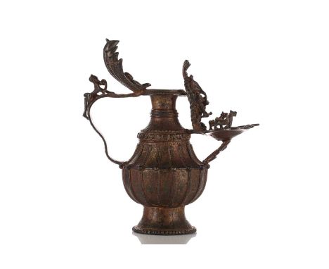 A Nepalese gilt-bronze Sukunda (ritual oil lamp) with applied naga mantle and a figure of Ganesh and Hanuman to the handle an