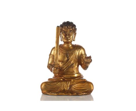 An Eastern gilt-bronze figure of Fudo Myo-o seated in the lotus position with rope and sword in hand. 11.5 cm wide x 9.5 cm d