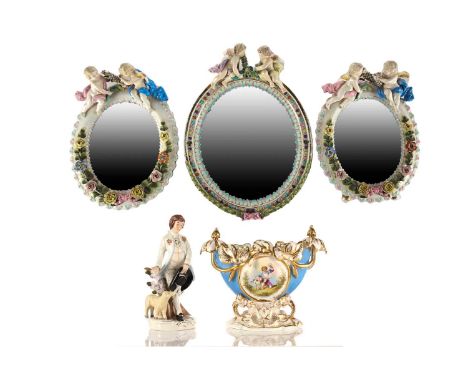 A Continental porcelain oval wall mirror, 19th century possibly Dresden, the mantle comprised of a pair of winged putti holdi