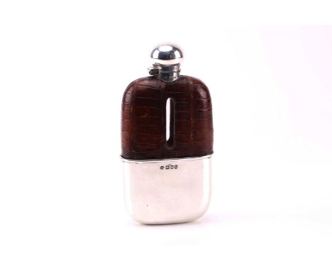 An Edwardian silver and crocodile leather hip flask. London 1903 by William Hutton and Sons, the pull-off beaker with a gilde