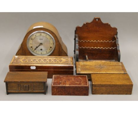 A mantle clock, a desk stand and various wooden boxes.