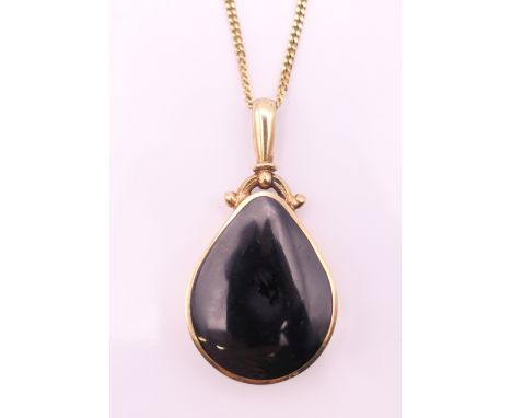 A 9 ct gold, abalone and onyx pendant on a 9 ct gold chain. Pendant 4.5 cm high including suspension loop, chain 60 cm long. 
