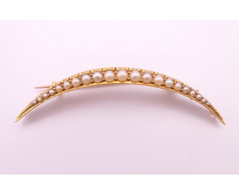 A 15 ct gold, seed pearl crescent moon form brooch.  5 cm high. 3.7 grammes total weight.