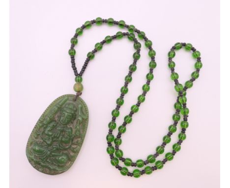 A jade pendant necklace.  Pendant 6 cm high, necklace 64 cm long. 