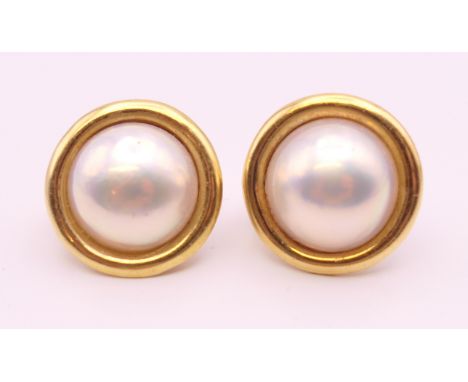 A pair of 9 ct gold and pearl earrings.  2 cm diameter.