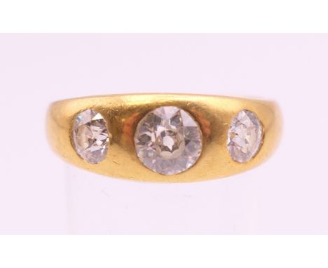 An 18 ct gold three stone diamond ring. The central stone spreading to approximately .75 carat. Ring size R/S. 8.3 grammes to