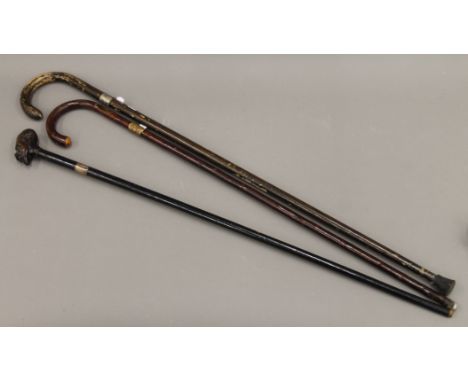 Three vintage walking sticks.