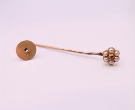 A boxed 15 ct gold ruby and seed pearl stick pin.  5.5 cm long. 2.3 grammes total weight.