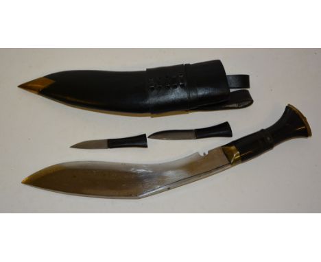 A Kukri with brass mounted horn handle and complete with two small knives in leather scabbard, overall length 40cms ++good co