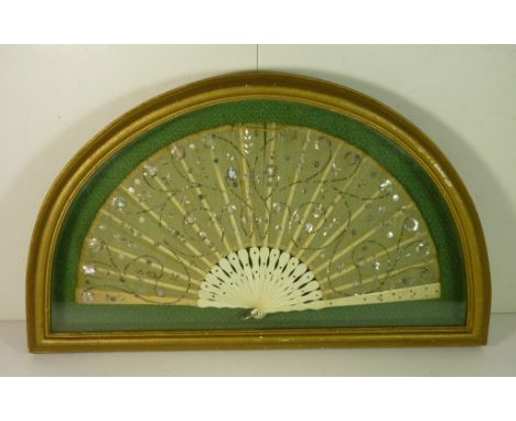 A late 19th Century "spangled" fan with carved sticks and guards and gauze leaf sewn with silver metal and mother of pearl an