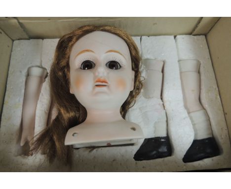 A box containing bisque dolls head, arms and legs (late 20th Century)