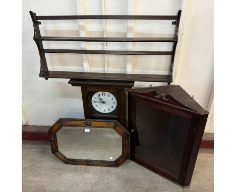 An oak wall clock, an oak corner cabinet, an Ercol plate rack and an oak mirror