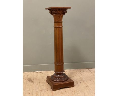 A 20th century cherrywood classical style pedestal, with fluted column and carved Corinthian capital, on a square plinth base