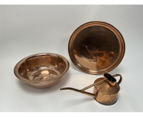 A large copper charger (d. 38.5cm), together with a hammered copper bowl (d. 36cm), and a copper watering can (l. 38cm) (3) 