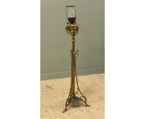 A Victorian brass floor-standing oil lamp, with adjustable height, with tripple griffin motif above scrolled supports and pad