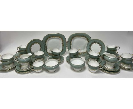 An Aynsley Sherwood pattern part tea service comprising, two cake plates with gilt scrolls and border, a matched pair of milk