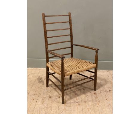 A 19th century Arts and Crafts style beech armchair, with woven rush seat and ladder back, on turned tapered supports: h.x