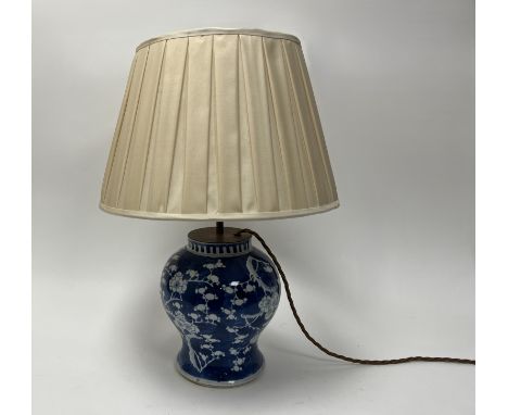 A 20thc Chinese ginger jar of bulbous form converted into a table lamp and decorated with blue and white prunus blossom, comp