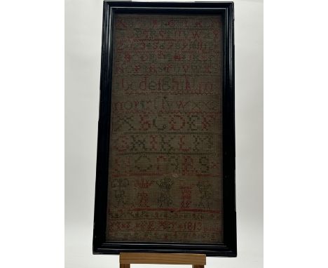 An Early 19thc needlework alphabet and number sampler in green and red thread, by M.L. Pext, dated 1813, in a glazed frame. (