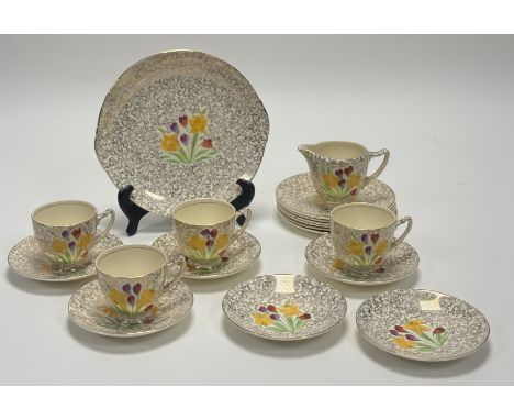 An English Palissy hand-painted with spring flowers and gilt decoration part tea service comprising, a milk jug, four teacups