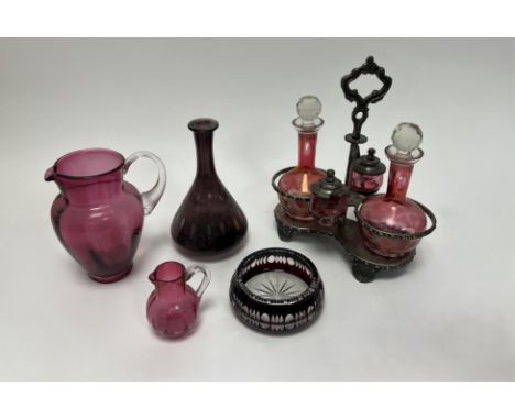 A cranberry glass jug with clear handle together with a smaller example (h. 18cm and h. 9cm),  a amethyst glass squat bulbous