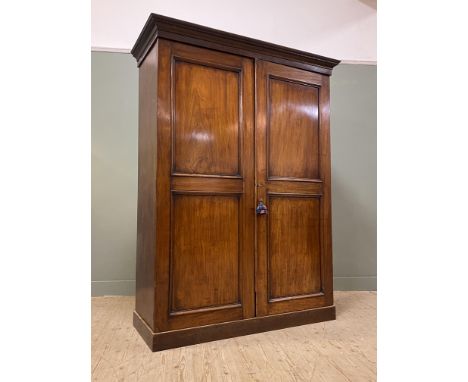 A Victorian mahogany wardrobe, with moulded cornice above a pair of panel doors enclosing a fitted interior with hanging rail