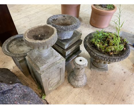 A collection of stone garden ornaments, to include a classical urn raised on a fluted plinth, a bird bath, two garden planter