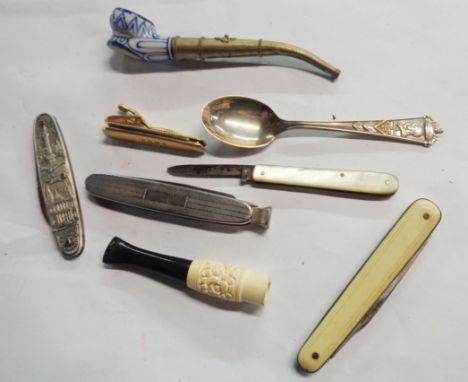A bag containing a quantity of collectable items including a silver plated commemorative spoon, a ceramic bowl pipe, a quanti