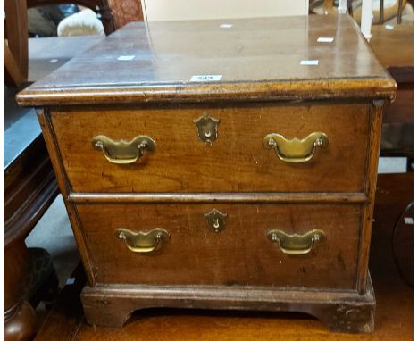 A 19th Century oak commode chest with flanking drop handles, set on bracket feet - top split