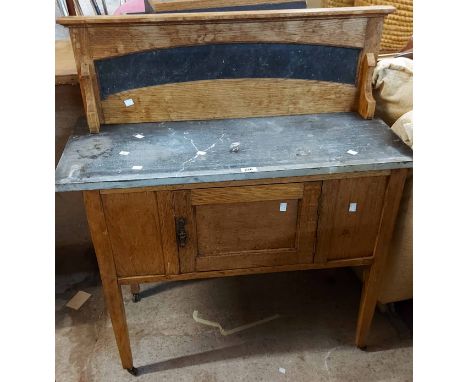 A 91cm Edwardian light oak washstand with raised splash back, slate top and single cupboard door, set on square tapered legs 