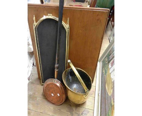 A brass coal scuttle of helmet form - sold with a brass framed wire meshed folding fire guard and a copper warming pan