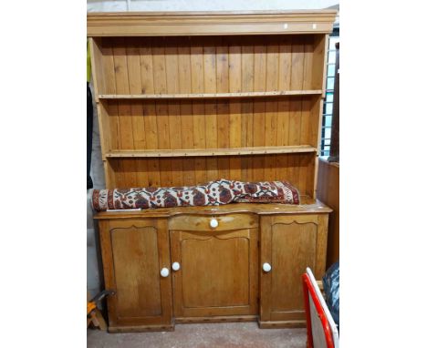 A 1.55m old pine two part dresser with moulded cornice and two shelf open plate rack with cup hooks, over a serpentine fronte