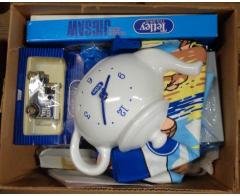 A box containing Tetley memorabilia including a clock in the form of a teapot, tea towels, teapot, toy car, etc.