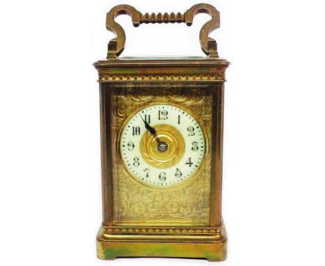 A late 19th Century brass and bevelled glass cased carriage clock with decorative engraved dial border and platform escapemen