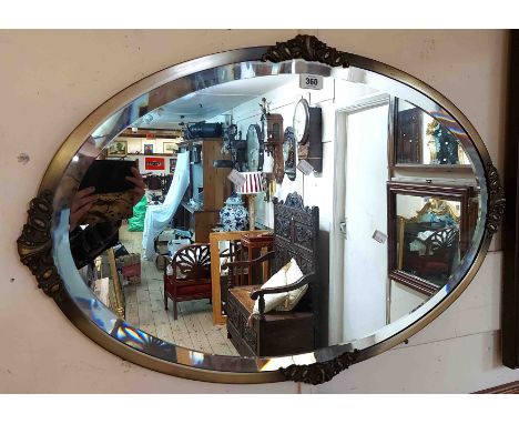 A vintage metal framed bevelled oval wall mirror with applied decoration - sold with a small embossed brass framed convex wal