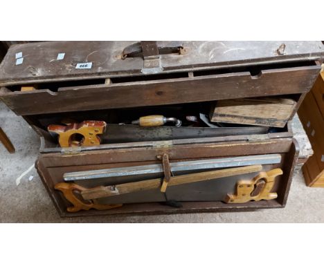 An old wooden carpenter's chest containing a quantity of tools including saw, planes, etc.