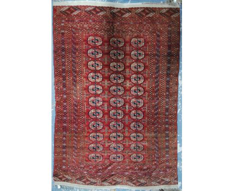 An antique Turkmen rug, late 19th/20th century, the geometric design of guls in three rows on red-brown ground, 1.68 x 1.07 m