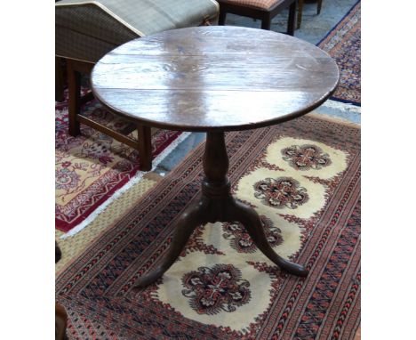 An 18th century country oak tripod table, the circular snap top over a birdcage, raised on a turned column to pad feet, 67 di