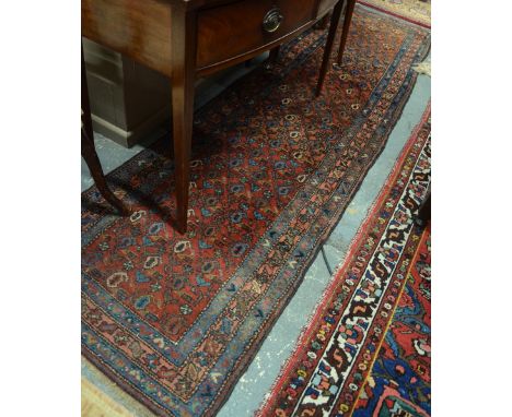 An old Persian Hamadan runner, the field of repeating boteh design on red ground, 2.88 x .78 m