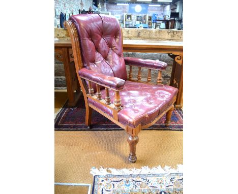 An oversized Victorian oak framed buttoned red leather library armchair on turned front legs to ceramic castors Condition Rep