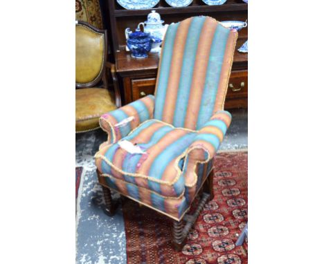 An 18th century style upholstered high back armchair over a bobbin turned under frame, the back leg stamped 8660 Condition Re