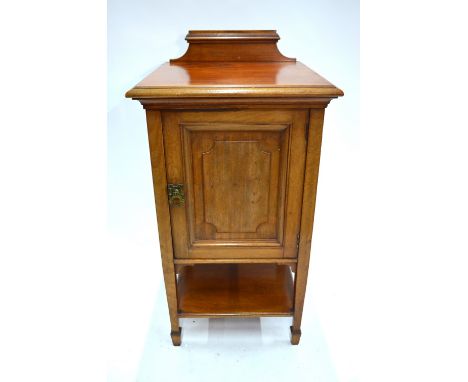 Howard & Sons, London, an early 20th century walnut pot cupboard having a fielded panelled door over an open shelf, bears mak