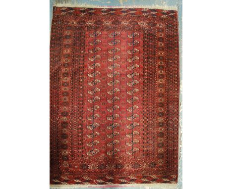 An antique Turkmen rug, late 19th century, the geometric design of three rows of guls on red-brown ground, 1.77 x 1.26 m Cond