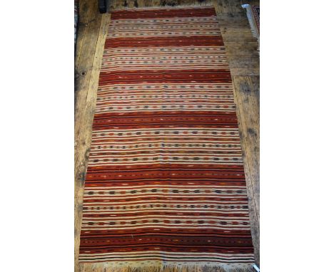 An antique Caucasian kelim, the multi-coloured design in horizontal stripes on ivory and red ground, 2.96 x 1.34 m Condition 