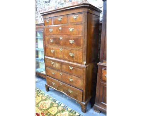 A George III cockbeaded and featherbanded walnut chest on chest, in two parts, the upper with canted reeded sides, three shor