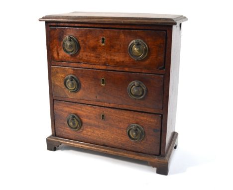 An early 19th century mahogany three-drawer miniature chest with brass plate and ring handles and bracket feet, 28 cm high
